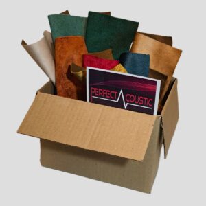 materialmusterbox-stoffmuster-bestellen Geöffnete Musterbox mit zahlreichen Stoffmustern in Grün, Blau, Beige, Braun und Rot sowie einer Perfect-Acoustic-Karte auf hellem Hintergrund. Die unterschiedlichen Farben und Oberflächenstrukturen sind deutlich sichtbar.