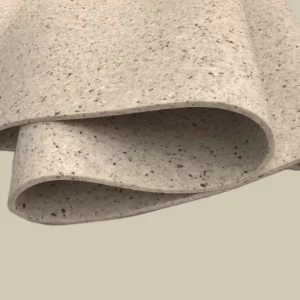 elitexa-teppichunterlage-gefaltete-bahn Gefaltete Elitexa Teppichunterlage in Naturfarbe mit weichen Rundungen, die die biegsame Beschaffenheit und die fein gesprenkelte Oberflächenstruktur hervorheben.