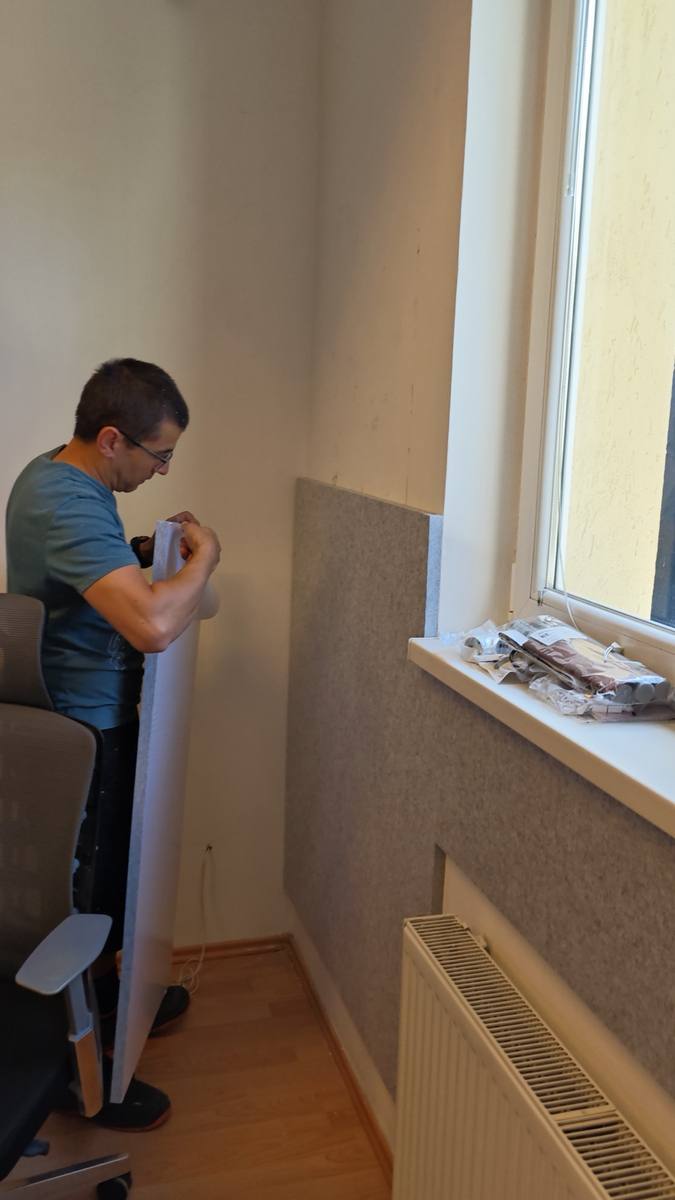 Anbringen einer Akustikplatte an der Wand mit einer selbstklebenden Rückseite