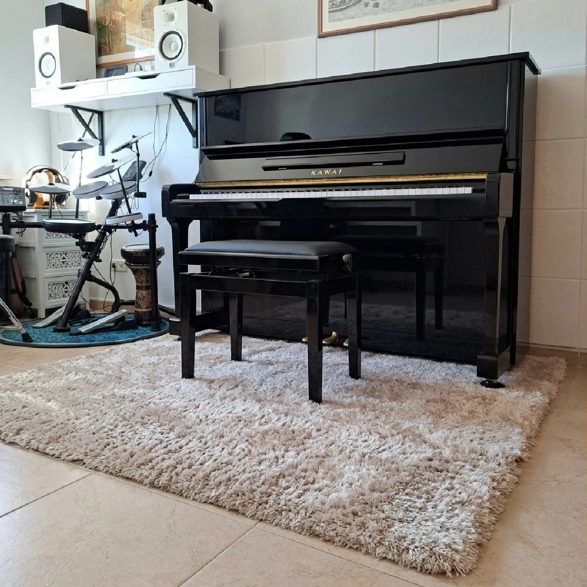 Kundenfoto eines beigen Professional Calm Akustikteppichs unter einem Klavier in einem Musikzimmer. Der dichte Flor sorgt für eine wohnliche Atmosphäre und unterstützt eine angenehmere Raumakustik beim Musizieren.