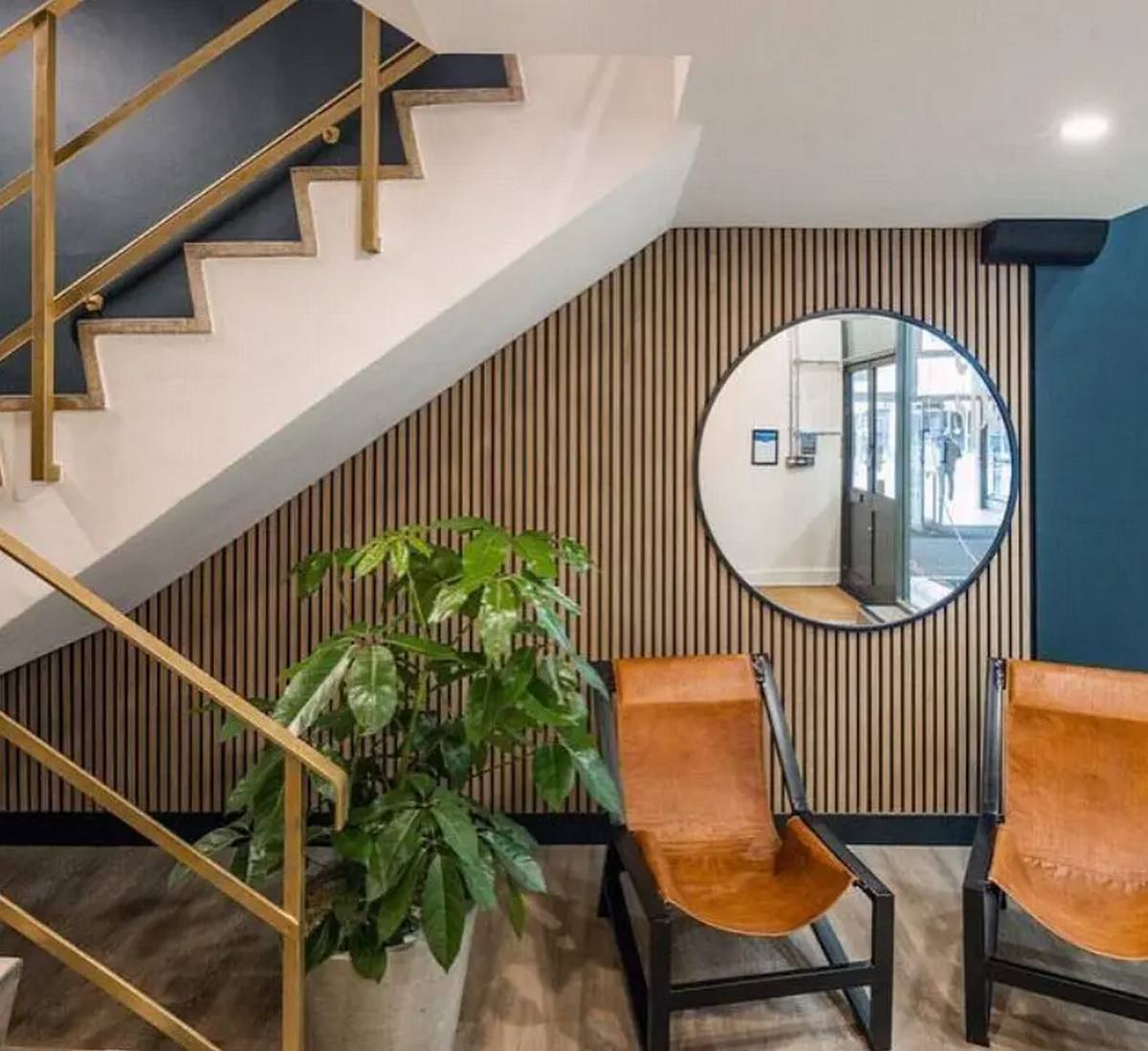 Holz-Lamellen Akustikpaneele unter der Treppe in einem modernen Eingangsbereich.Kurzbeschreibung