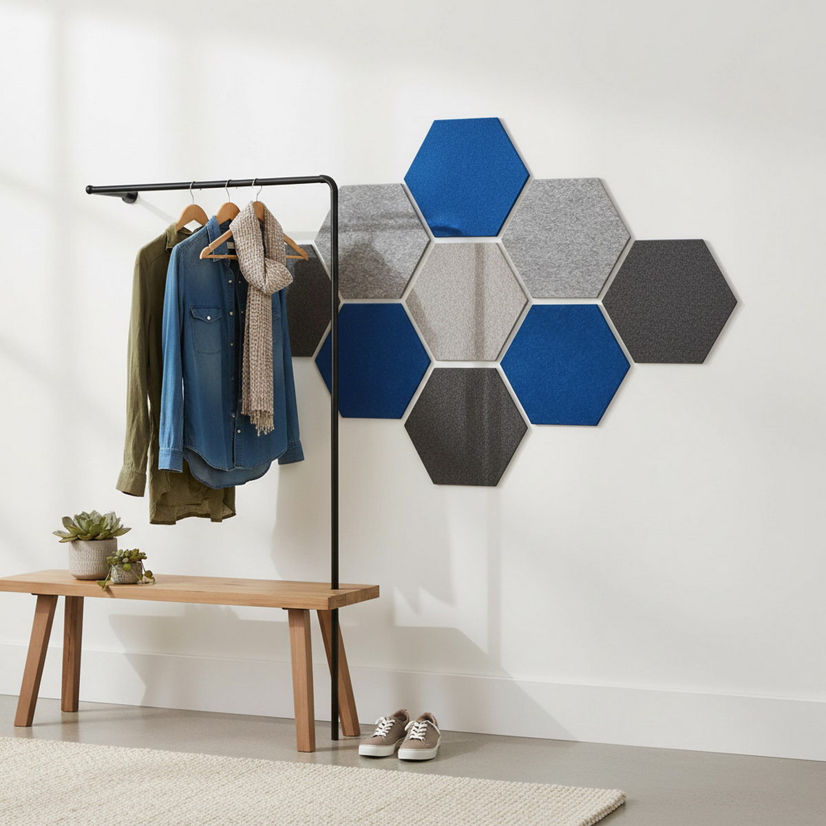 Hexagonale Akustikpaneele in Blau und Grau an der Wand eines modernen Flurs.