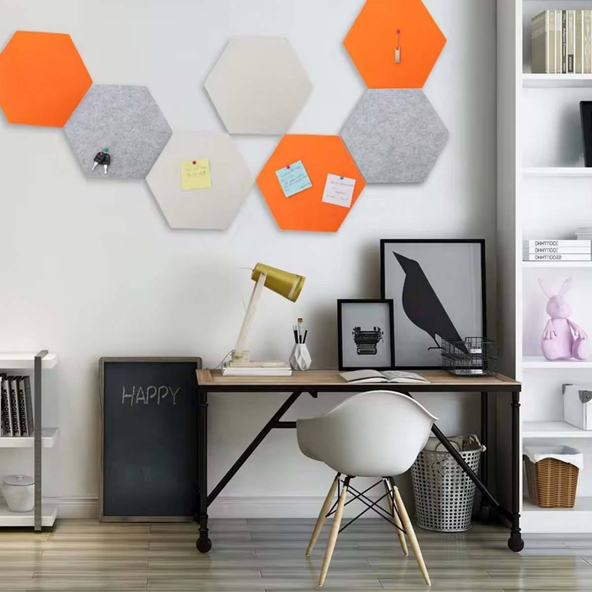 Hexagonale Akustikpaneele in Orange und Grau an der Wand eines modernen Home-Office.