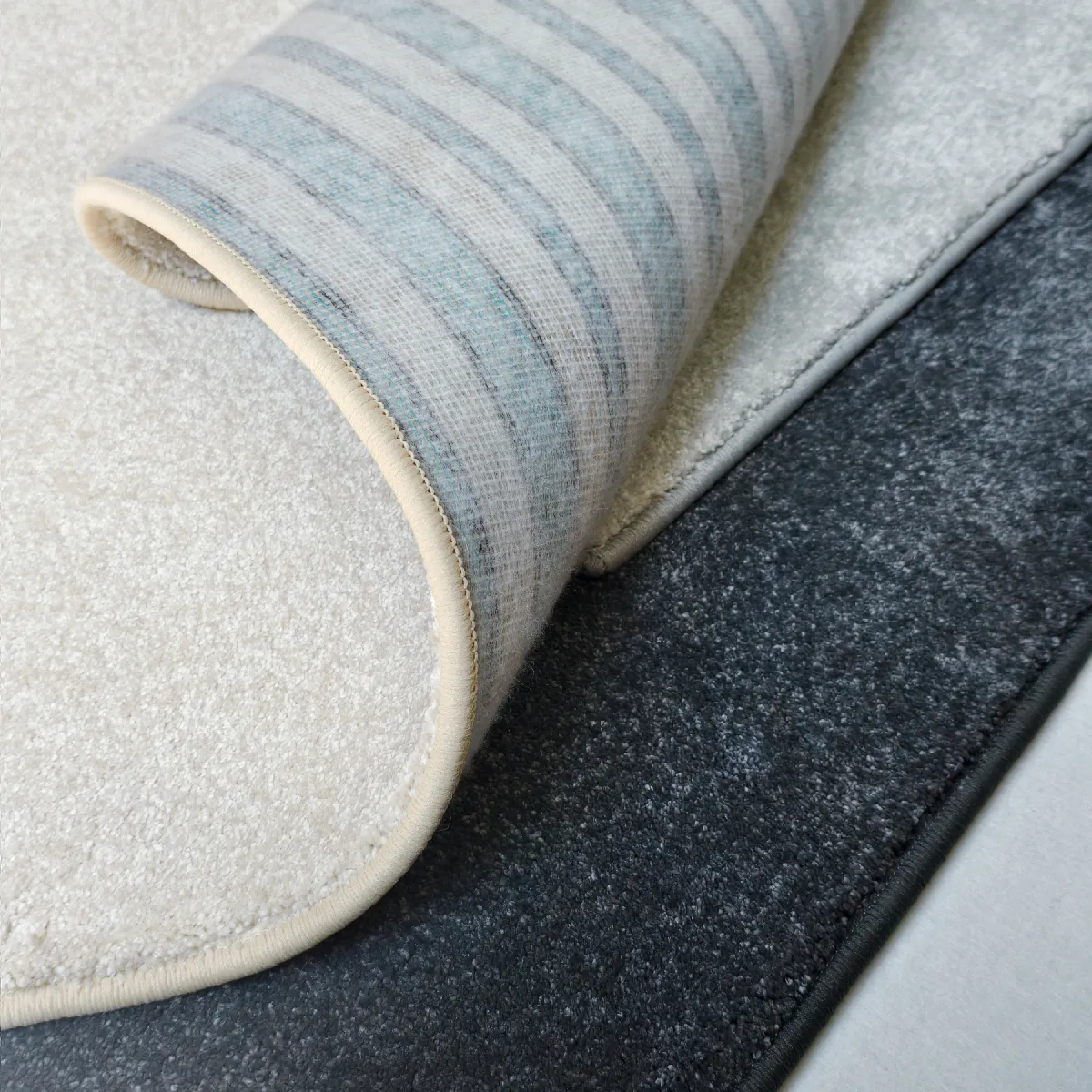 Aurora Teppich in drei Farben nebeneinander: Beige, Silber und Anthrazit, mit Rückseite
